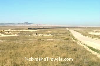Scenic Gravel Toadstool Road to Toadstool Park with long coal train - Nebraska Grasslands & Badlands area